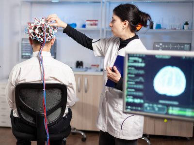 Back view of man patient wearing performant brainwave scanning headset